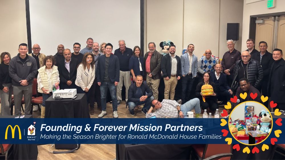 Photograph of a group of people posing together in a conference room, celebrating the partnership between McDonald's and Ronald McDonald House Charities. A blue banner at the bottom highlights "Founding & Forever Mission Partners" with a circular inset showing a colorful Ronald McDonald House decorated with hearts, emphasizing support for families.