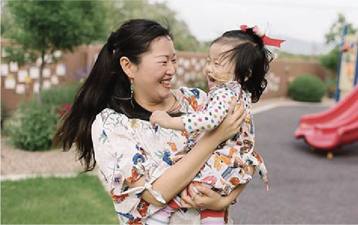 A mother holds her child closely while playing together on playground